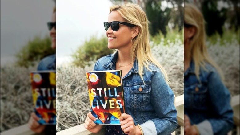 Reese Witherspoon holding a copy of Still Lives