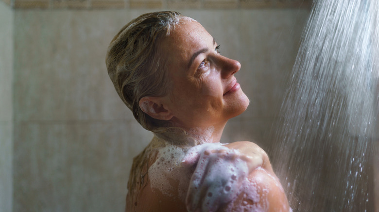 Older woman washing her hair in the shower