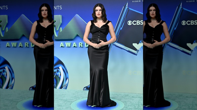 Ella Bright holding her hands together and wearing a silky, black dress
