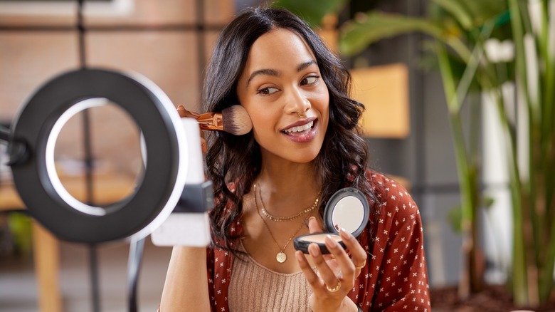 Woman applying powder foundation