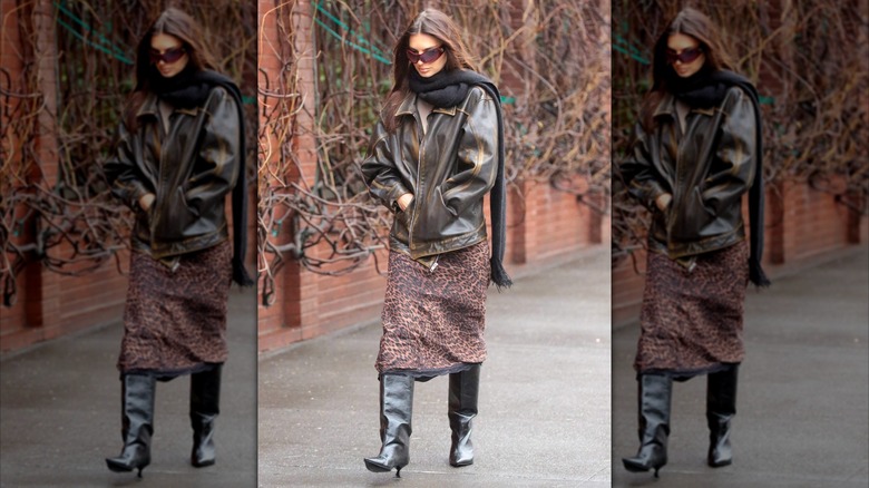 Emily Ratajkowski pictured wearing a jaguar-print skirt with black boots and a leather jacket