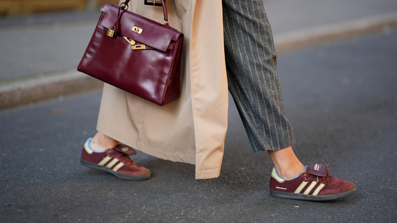 A stylish, unseen woman wearing reddish brown suede sneakers