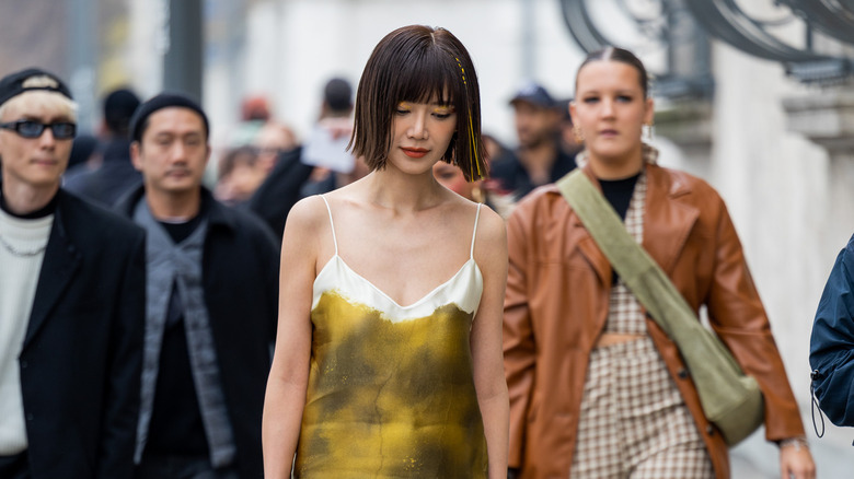 Woman in gold-toned slip dress