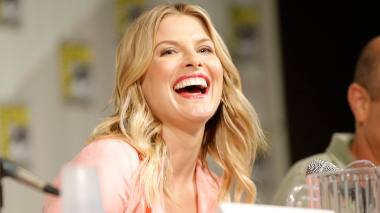 Ali Larter with beach waves wearing a pink top and coral lipstick