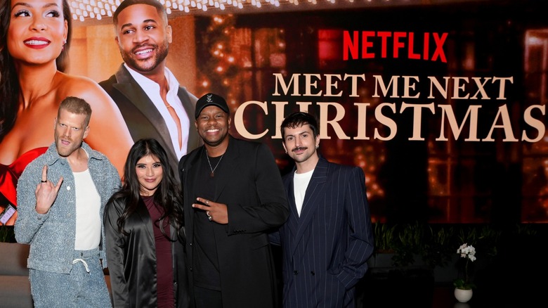 Pentatonix posing by a Meet Me At Christmas poster in 2024