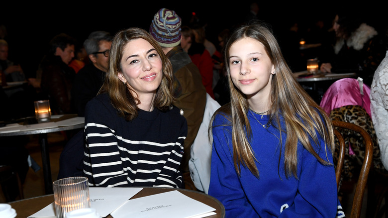 A teenage Romy Mars wearing a blue sweater and