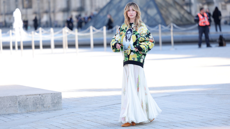 Eve Jobs walking in front of the Louvre