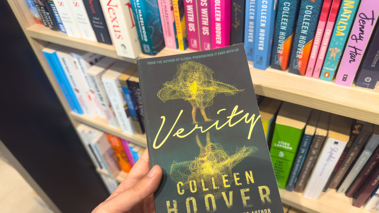 Woman holding Verity by Colleen Hoover