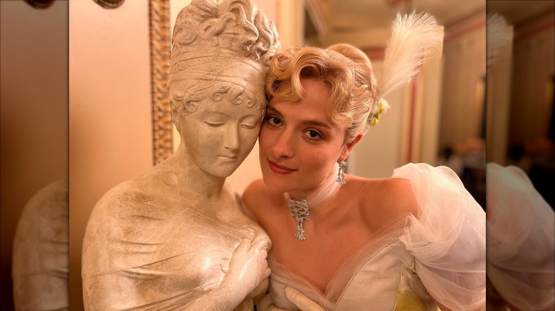 Louisa Jacobson posing in her "The Gilded Age" costume next to a statue