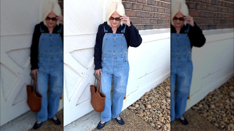 A woman in a navy sweater with overalls