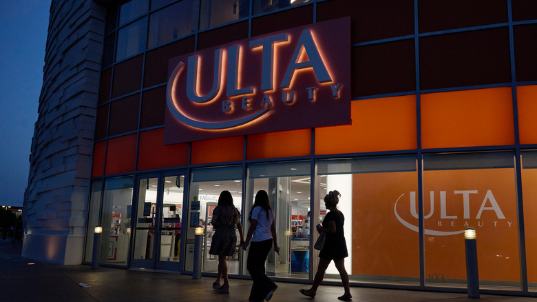 People walk in front of an Ulta Beauty store