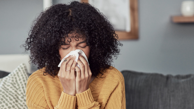 Woman blowing nose