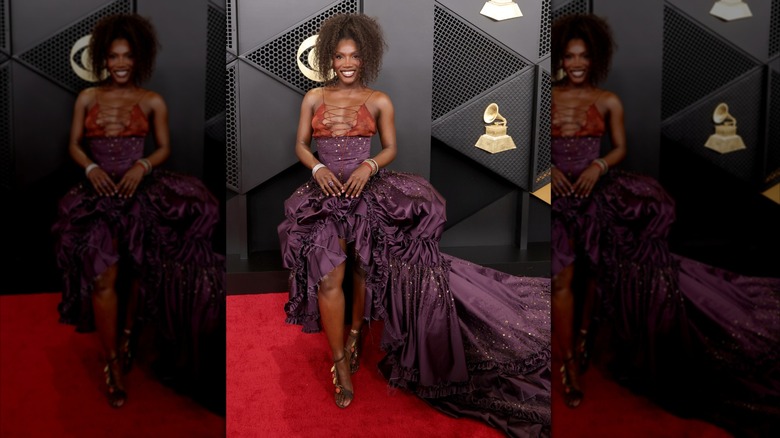 Doechii at the 2026 Grammys in a purple dress with an orange bra top