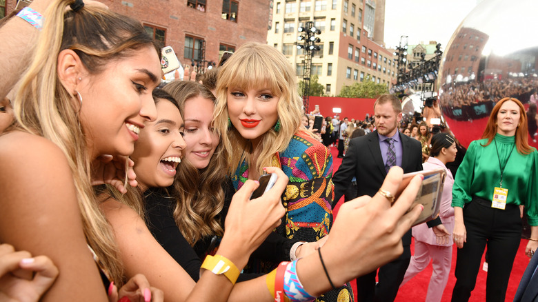 Taylor Swift posing with fans