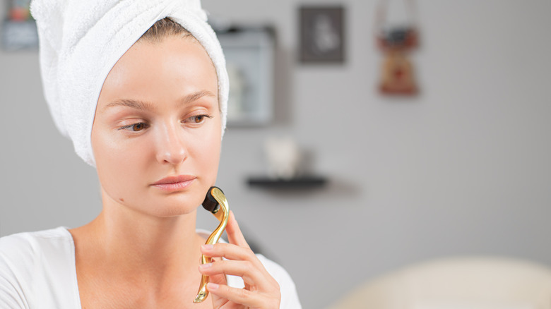 A woman derma rolling her face