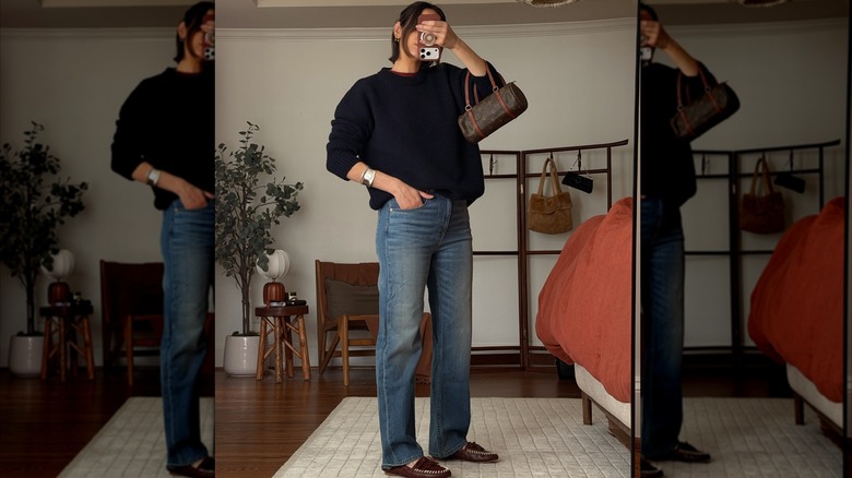 Style influencer Natalie Helen takes a mirror selfie to show off her OOTD featuring brown moccasins, straight-leg jeans, and an oversized sweater