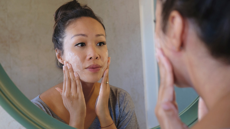 Woman looking into mirror with concerned expression