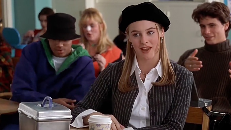Cher wearing a pinstripe blazer with a black beret
