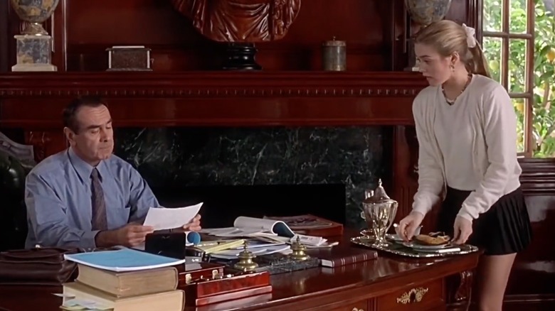 A screen grab of Cher with her father in his study while she serves him tea