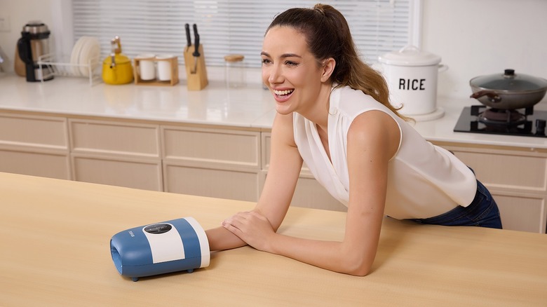 Woman with CINCOM hand massager leans over counter top