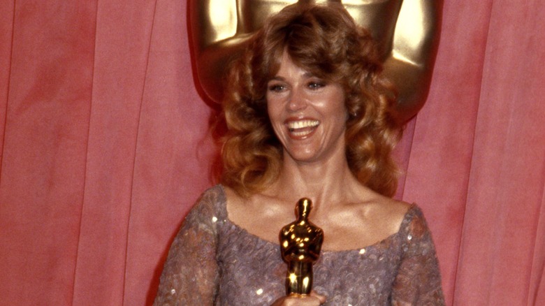 Jane Fonda smiling and holding her Oscars at the 1979 Academy Awards