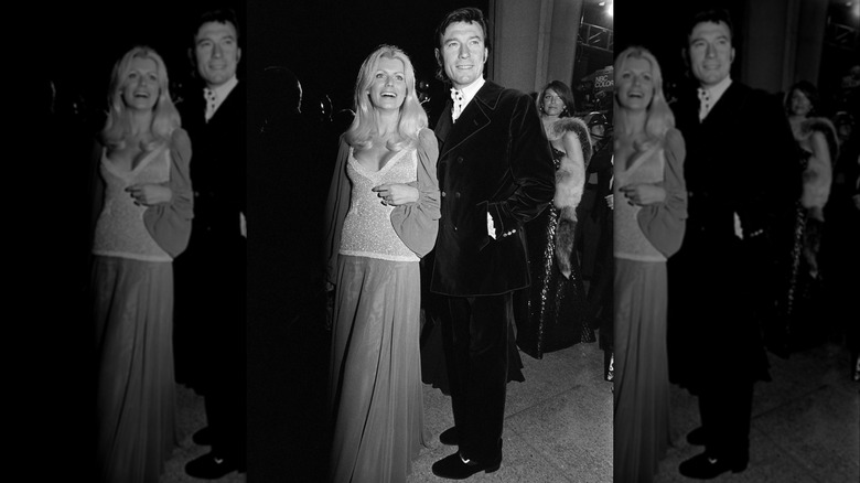 Black-and-white photo showing Paulene Stone smiling on the red carpet at the 1973 Oscars with Laurence Harvey