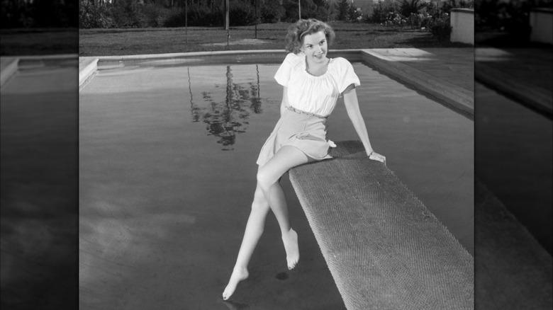 Judy Garland sitting on a diving board