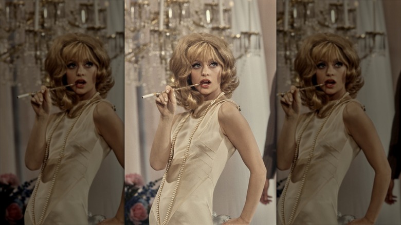 Goldie Hawn poses with a cigarette extender and a bouffant hairstyle