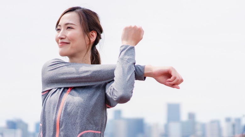 Woman stretches by city skyline