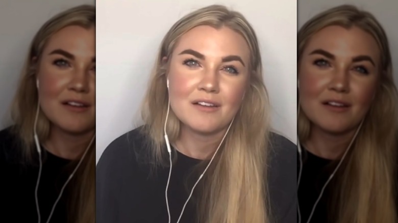 Erika Kirk with heavily defined eyebrows and wearing headphones