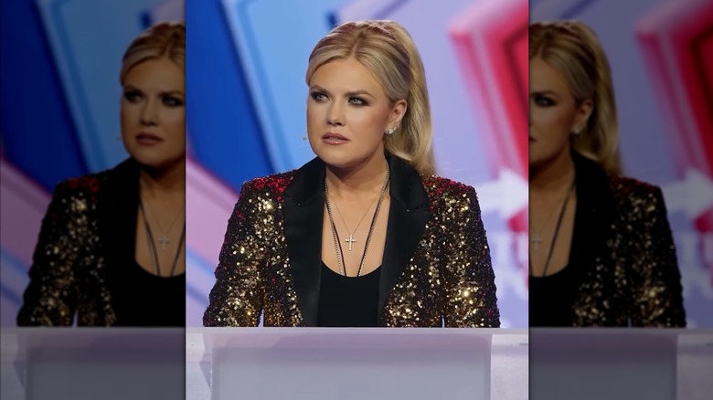 Erika Kirk standing at a podium and speaking in a sparkly jacket