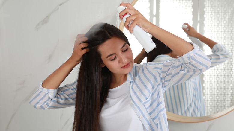 woman applying dry shampoo