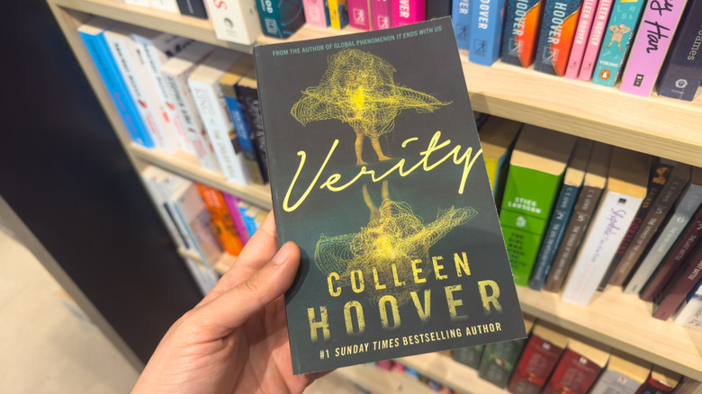 Woman holding Verity by Colleen Hoover