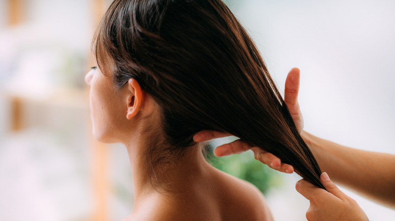 Woman receiving hair oil treatment 