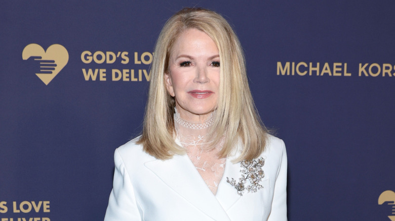 Blaine Trump poses in a white suit on a red carpet