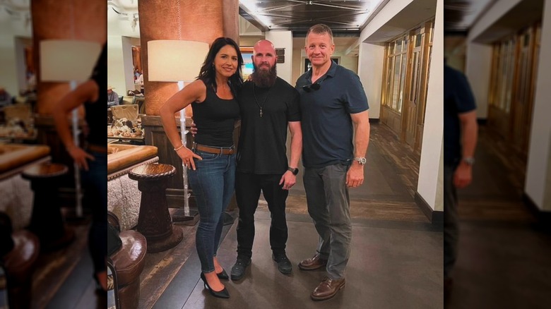 Tulsi Gabbard posing for a photo with two men in April 2024