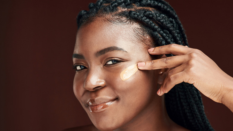 Woman applying concealer