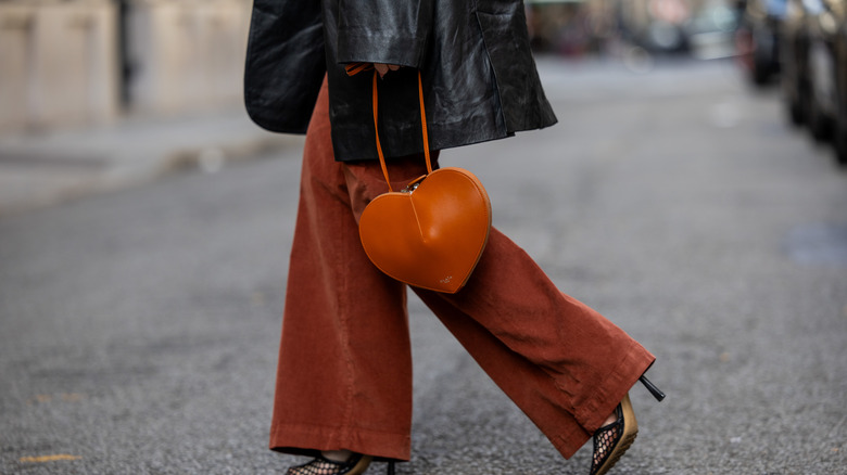 Woman wears corduroy pants with a leather jacket