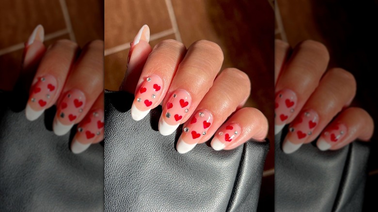 French manicure with red hearts and rhinestones