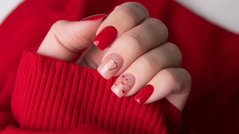Valentine's Day manicure with gold heart and tic-tac-toe