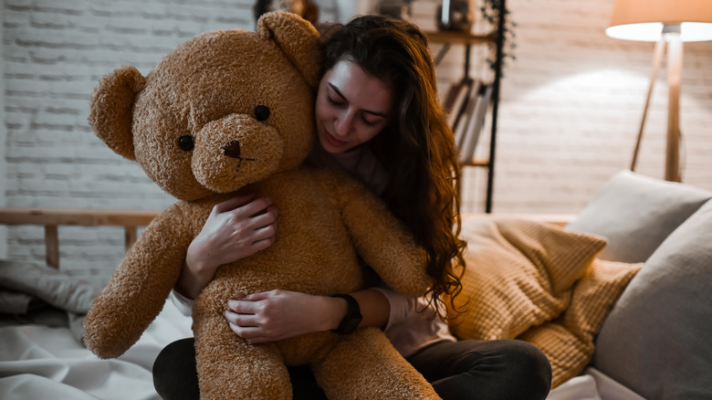 A woman holding a giant stuffed teddy bear