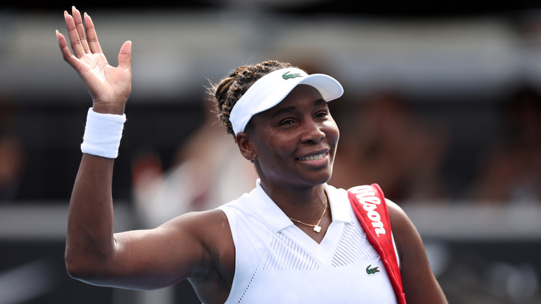 Venus Williams waves wearing Lacoste tennis gear