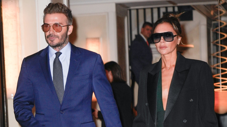 Victoria Beckham and David Beckham walking together and holding hands