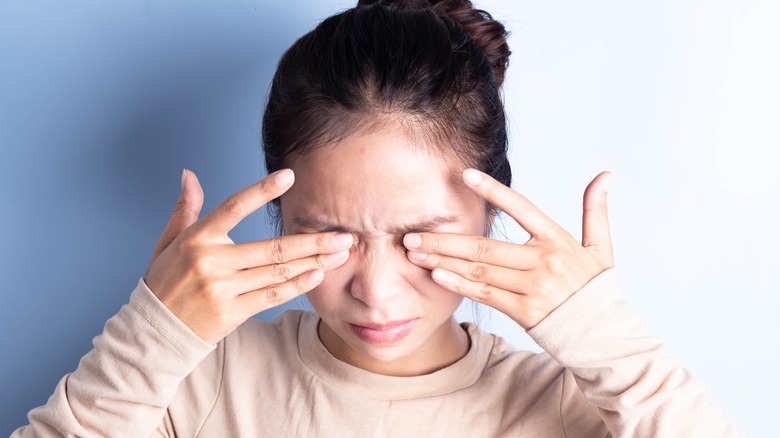 Woman rubbing eyes