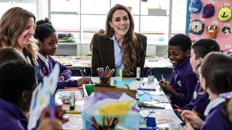 Kate Middleton sitting at a table with children in a classroom