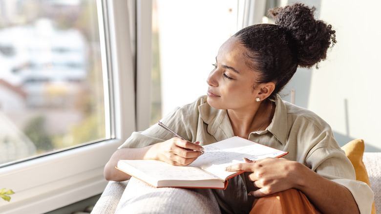 Woman reflecting while journaling