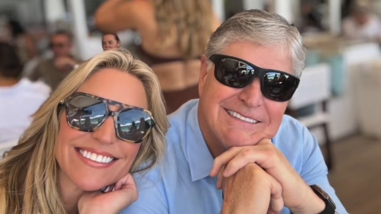 Ainsley Earhardt and Sean Hannity smiling wearing sunglasses