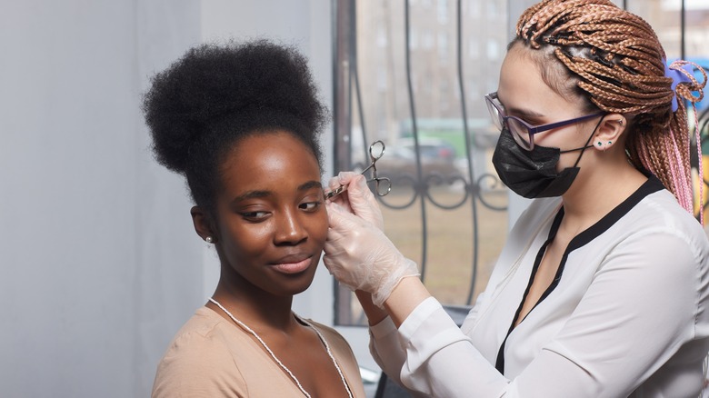 Person getting ear piercing