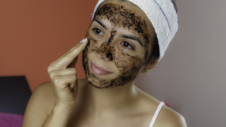 Woman applying coffee exfoliating scrub