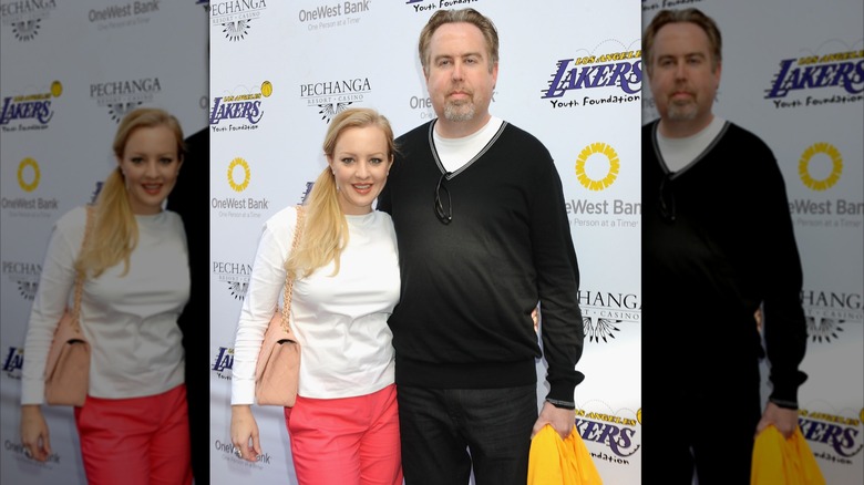 Wendi McLendon-Covey and husband Greg Covey standing next to each other at a Lakers game